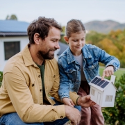 Un père et sa fille avec la maquette de leur maison de rêve